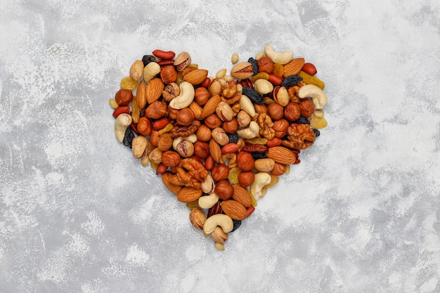 Assortiment van noten vorm van hart Cashewnoten, hazelnoten, walnoten, pistache, pecannoten, pijnboompitten, pinda, rozijnen. Bovenaanzicht