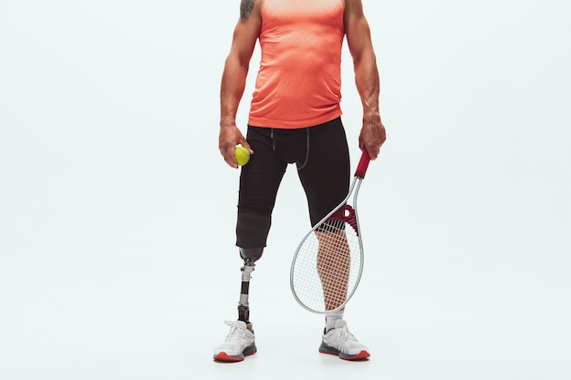 Gratis foto atleet met een handicap of geamputeerde die op wit wordt geïsoleerd. professionele tennisser met beenprothese training