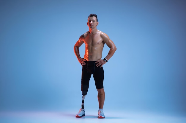Atleet met een handicap of geamputeerde geïsoleerd op blauwe studio achtergrond