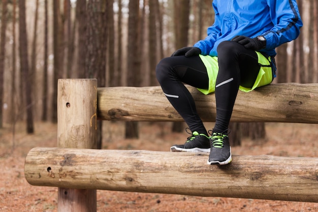 Atleet zittend op boomstammen