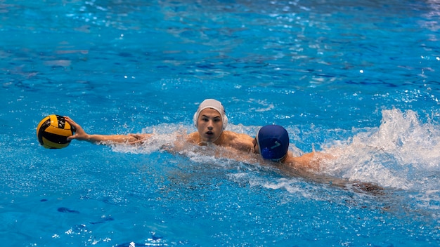 Gratis foto atleten die waterpolo spelen in het zwembad