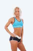Gratis foto atletische blonde fitness vrouw geïsoleerd op een witte achtergrond.