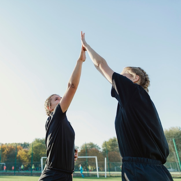 Atletische blonde vrouwen hoge vijf