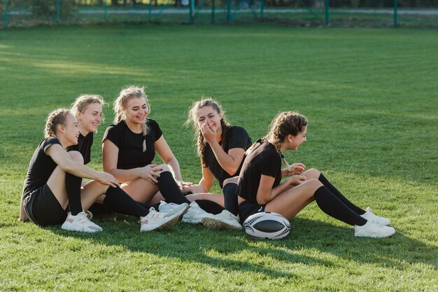 Atletische blondevrouwen die op gras zitten