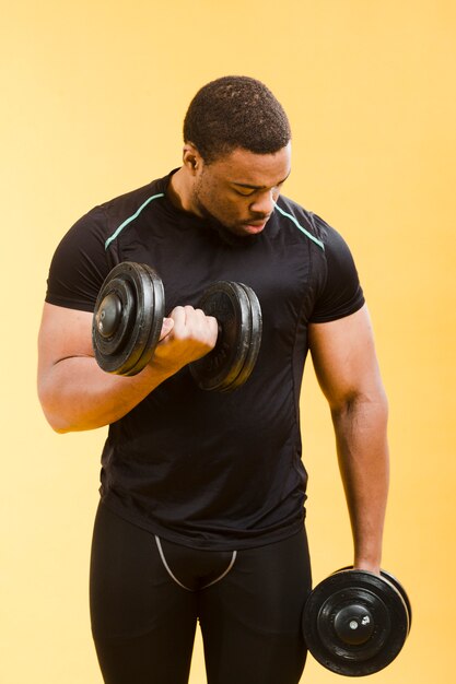 Atletische man met gewichten in gym outfit