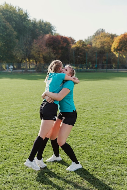 Atletische meisjes die elkaar omhelzen
