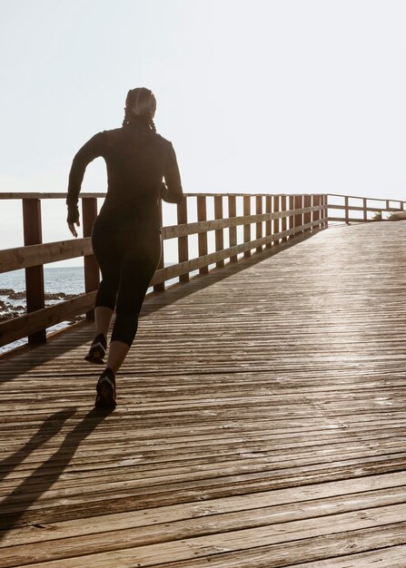 Atletische vrouw joggen aan het strand met kopie ruimte