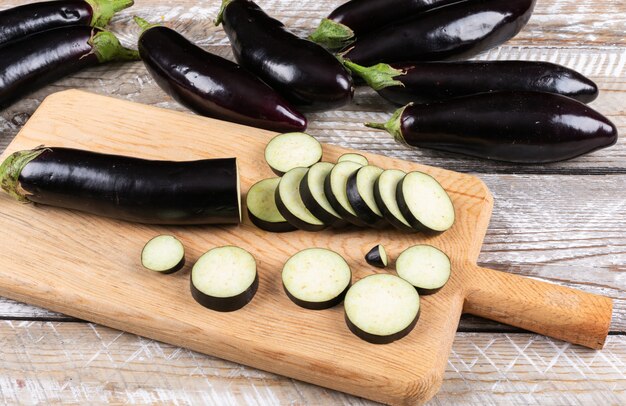 Aubergine en gehakte op een snijplank en houten zijaanzicht