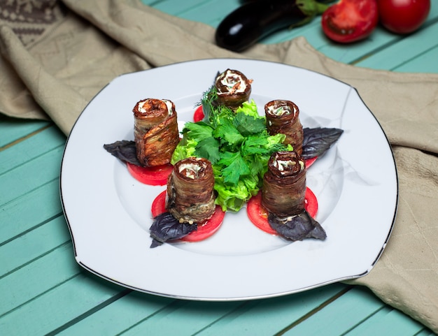 Auberginebroodjes met groentesalade in de witte plaat.