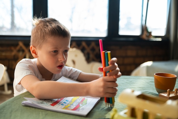 Gratis foto autistische jongen die thuis studeert