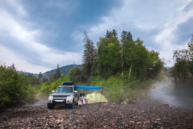 Auto kamperen bij bergrivier