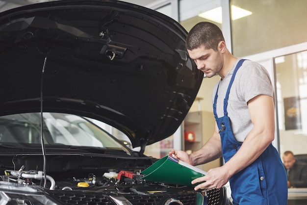 Automonteur man of smid met klembord op werkplaats.