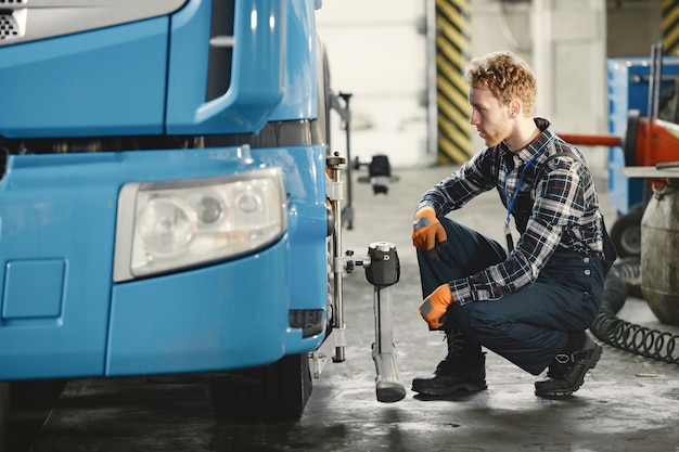 Automonteur repareert auto in garage met gereedschap