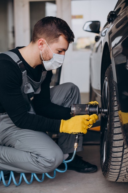 Gratis foto automonteur veranderende wielen in auto