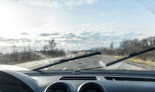 Autoruitenwissers reinigen de voorruiten bij het rijden bij zonnig weer