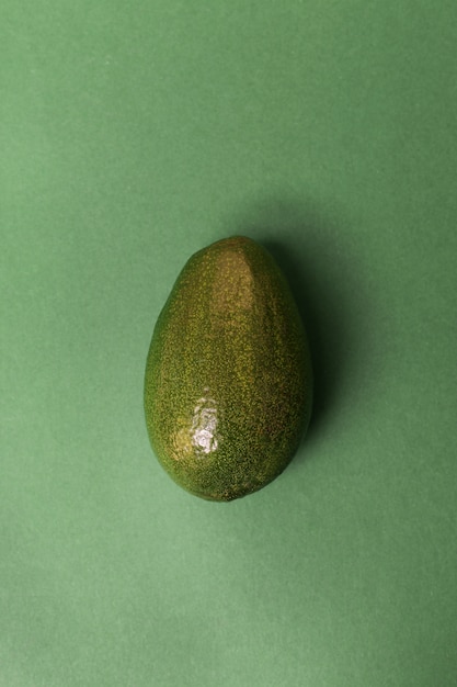Avocado die op groene oppervlakte wordt geïsoleerd