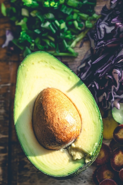 Avocadohelften op de keukentafel met gehakte verse groenten