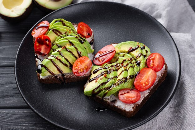 Avocadotoost op plaat met tomaten en saus