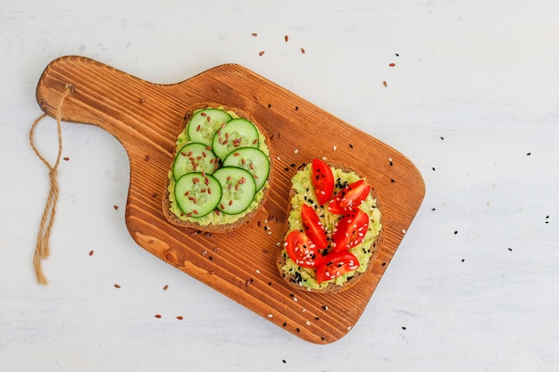 Gratis foto avocadotoost op volkorenbrood met groenten, gele en rode tomaten