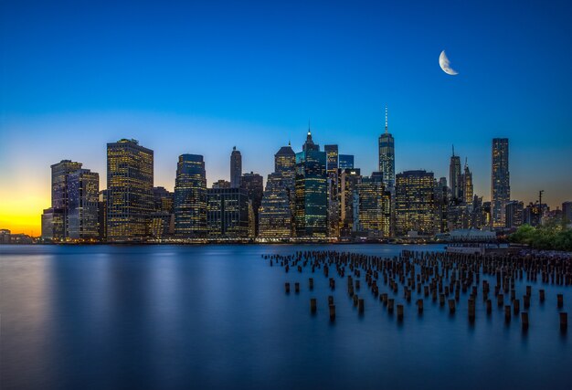 Avond Manhattan wolkenkrabbers en water met reflectie in