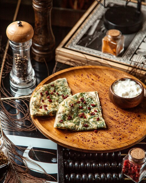 Azerbeidzjaanse gutab gevulde flatbread met kruiden gegarneerd met granaatappelpitjes en yoghurt