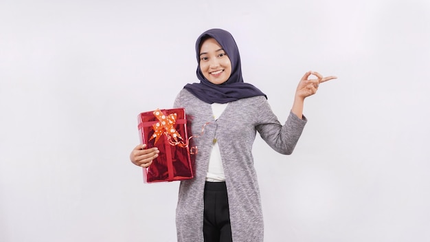Aziatisch meisje dat een gift draagt die zijspatie toont die op witte achtergrond wordt geïsoleerd