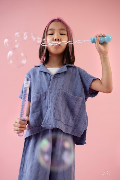 Gratis foto aziatisch meisje dat zeepbels maakt