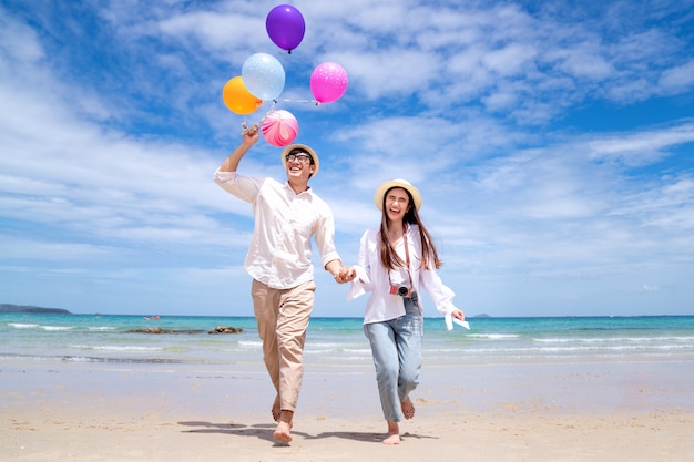 aziatisch paar dat en gelukkig op strand pattaya met ballon bij de hand in werking wordt gesteld