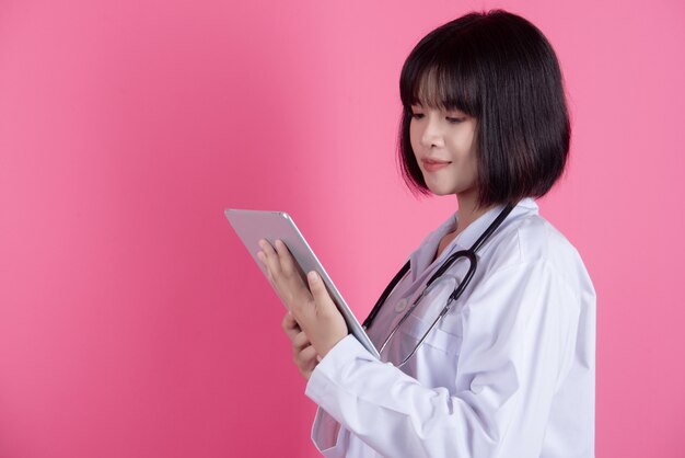 Aziatische arts vrouw met witte laboratoriumjas over roze