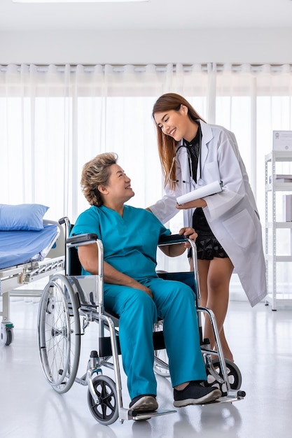Aziatische arts zorgt voor senior oudere vrouw vrouwelijke patiënt op rolstoel