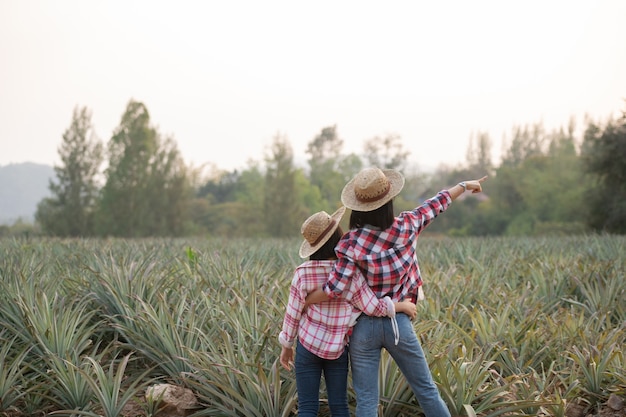 Aziatische boerin ziet de groei van ananas op de boerderij, Agricultural Industry Concept.