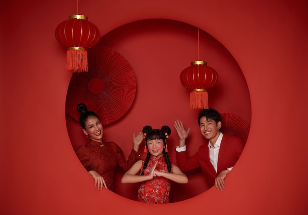Aziatische familie in rode casual kleding met gebaar van felicitatie groeten gelukkig Chinees nieuwjaar