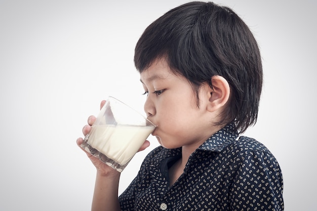 Aziatische jongen is het drinken van een glas melk