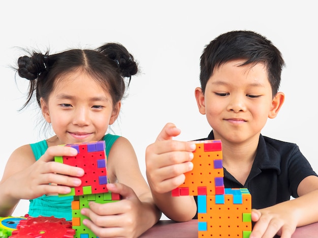 Aziatische kinderen spelen creatief spel met puzzel-plastic blokken