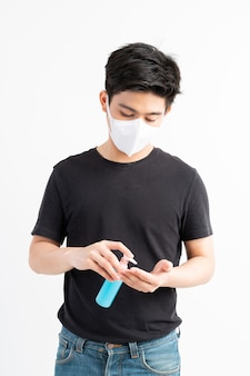 Aziatische man met gezichtsmasker met alcohol voor het wassen van handen om coronavirus covid-19 in quarantainekamer te beschermen