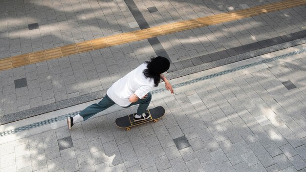 Aziatische man skateboarden in de stad