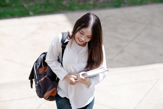 Aziatische studentenvrouw met laptop en zak, Onderwijsconcept