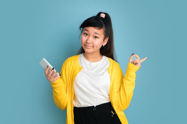 Aziatische tiener portret geïsoleerd op blauwe ruimte