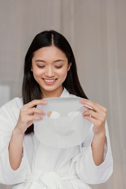 Gratis foto aziatische vrouw die een bladmasker gebruikt