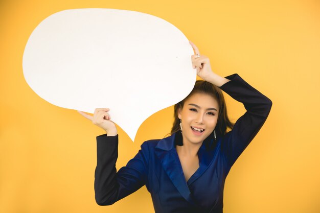 Aziatische vrouw die en omhoog aan toespraakbel houden kijken met lege ruimte voor tekst