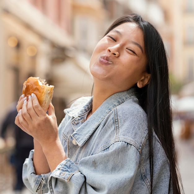 Aziatische vrouw die gelukkig is na het kopen van straatvoedsel