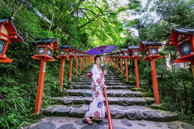 Aziatische vrouw die Japanse traditionele kimono draagt bij Kifune-Heiligdom in Kyoto, Japan.