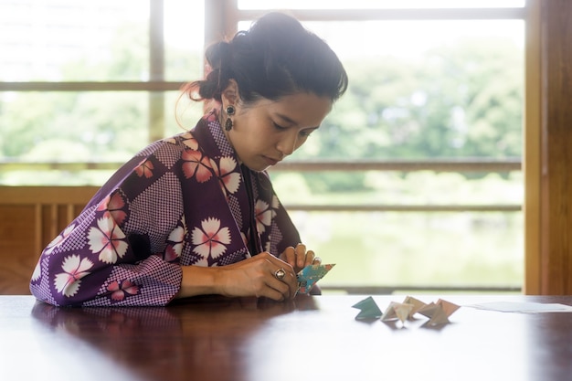 Aziatische vrouw die origami maakt met Japans papier