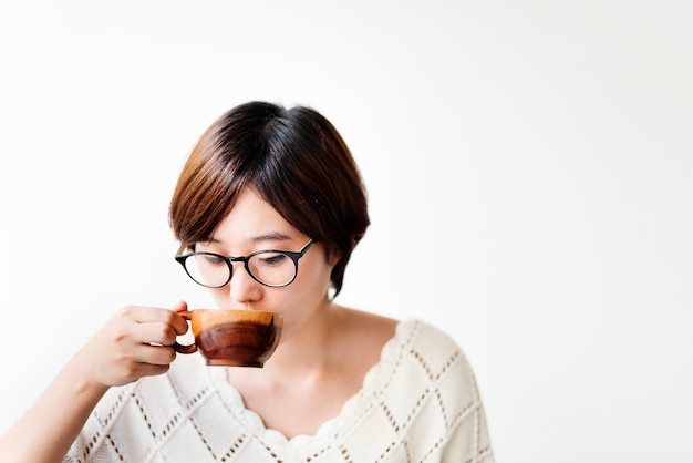 Aziatische vrouw het drinken koffie met houten kop