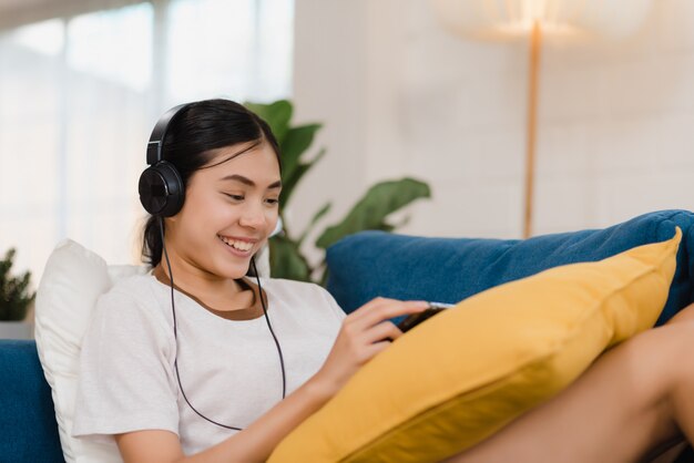 Aziatische vrouw het luisteren muziek en het gebruiken van tablet