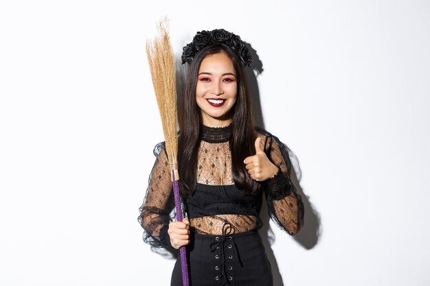 Aziatische vrouw in Halloween-kostuum het stellen