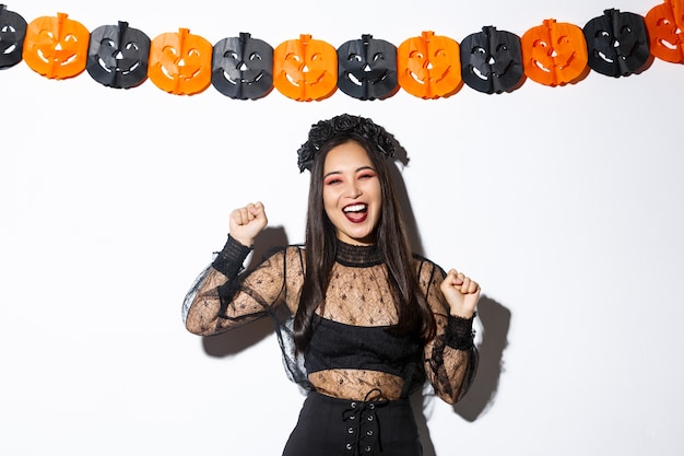 Gratis foto aziatische vrouw in halloween-kostuum het stellen