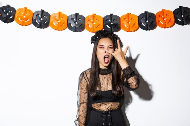 Aziatische vrouw in halloween-kostuum het stellen
