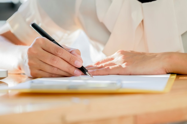 Aziatische zakelijke vrouw ondertekend een contract document een overeenkomst maken.
