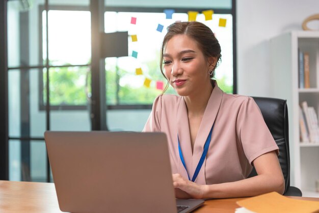 Aziatische zakenvrouw die op een laptop op kantoor werkt Succesvolle Aziatische zakenmensen die op de computer werken